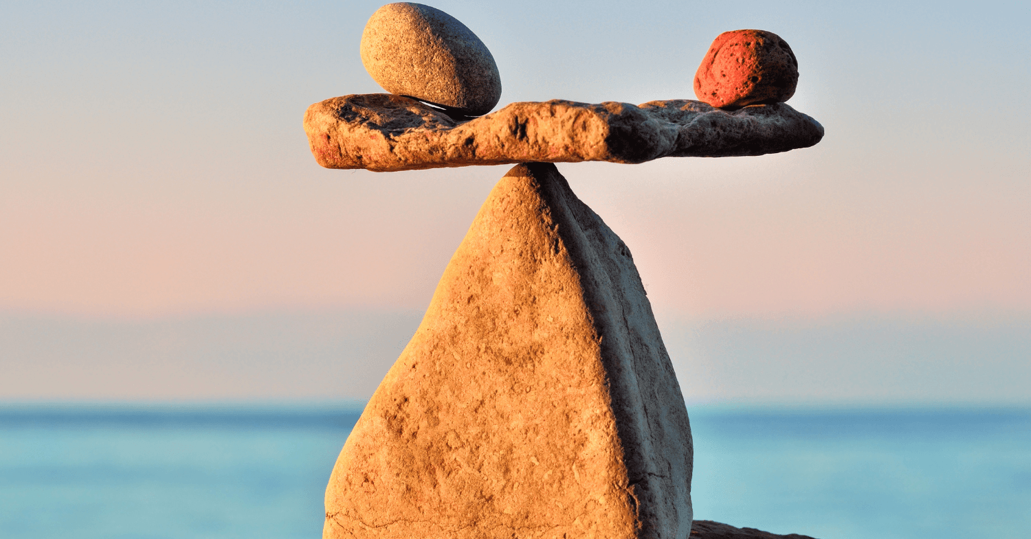 Balanced stones stacked on a rock at the seaside at sunset